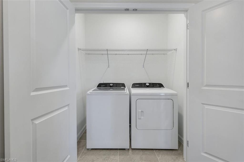 Dedicated laundry closet with ceramic tile flooring and wire shelving
