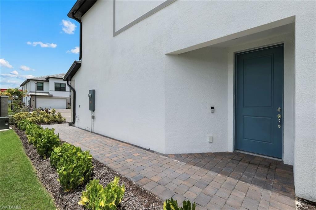 Contemporary exterior with white stucco finish, a covered entry, and a contrasting blue entry door