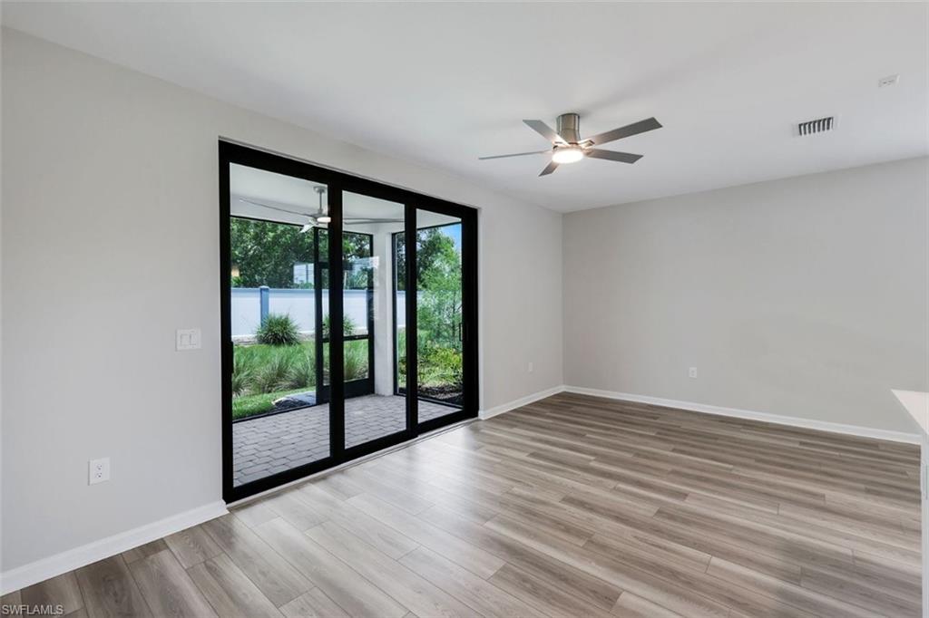 Expansive living area featuring wood-finish flooring and a modern ceiling fan