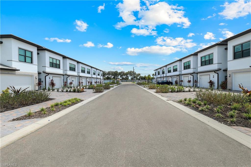 Modern townhome exteriors featuring white stucco, dark trim, and individual garage access