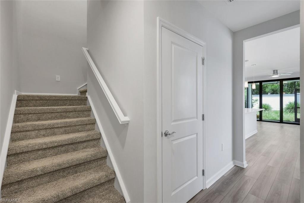 Carpeted staircase with white handrail, leading to an upper level