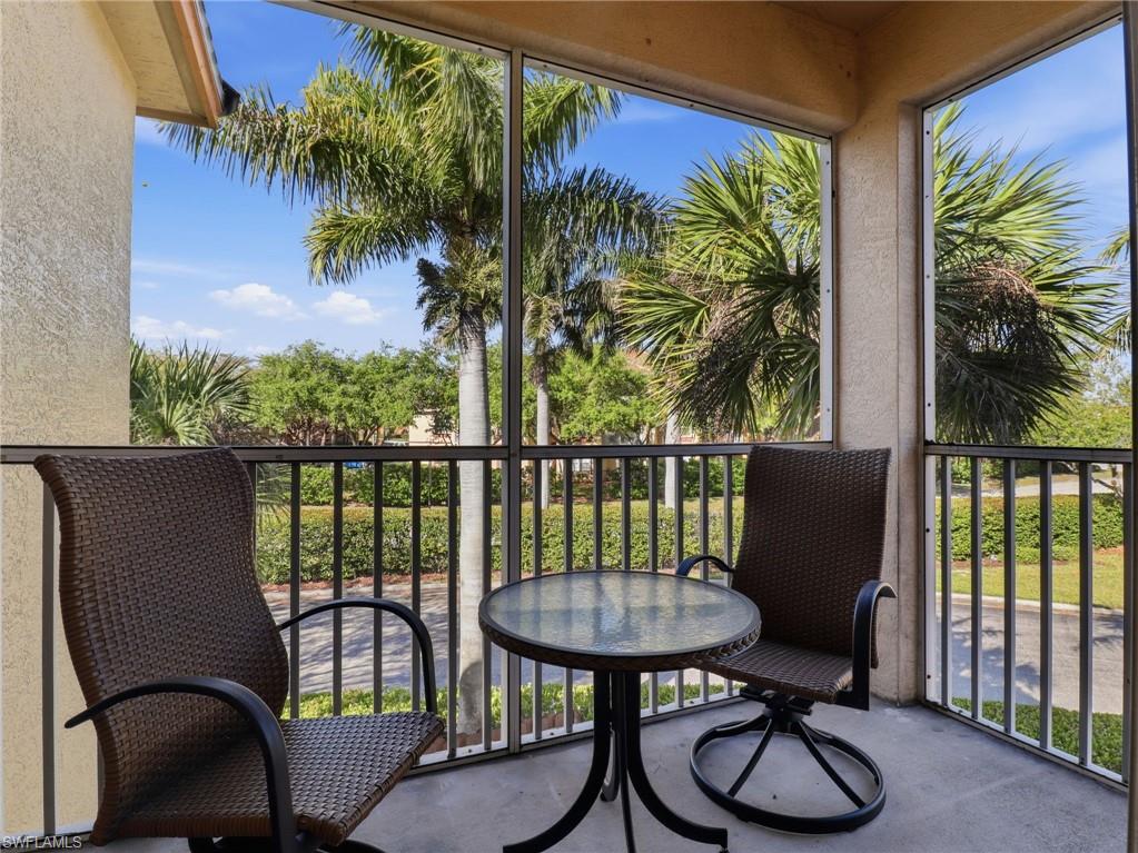 Screened balcony with textured stucco walls, concrete flooring, and a metal railing