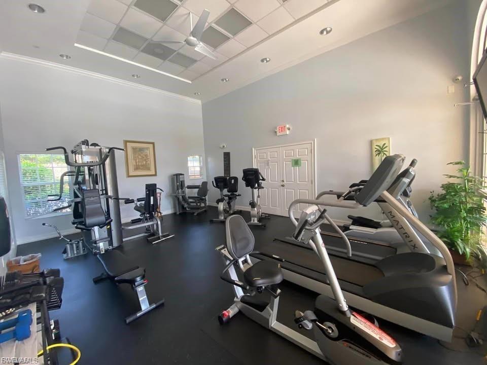 Spacious fitness center featuring high ceilings, recessed lighting, and a ceiling fan