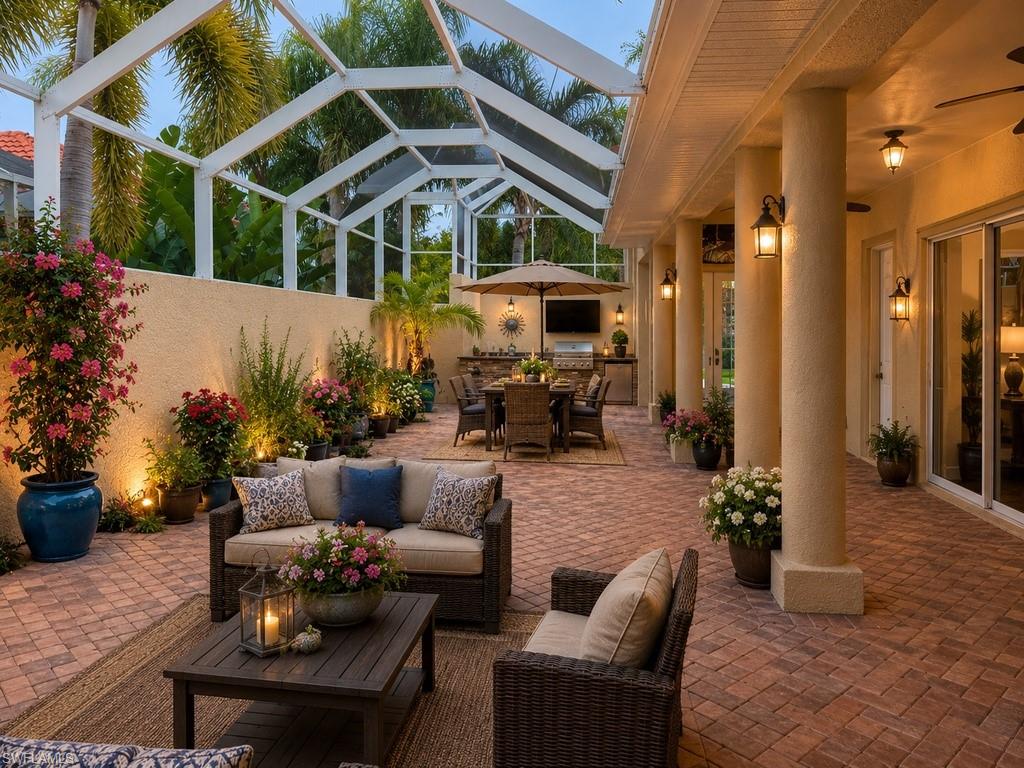 Expansive screened patio featuring brick paver flooring and an outdoor kitchen with integrated grill