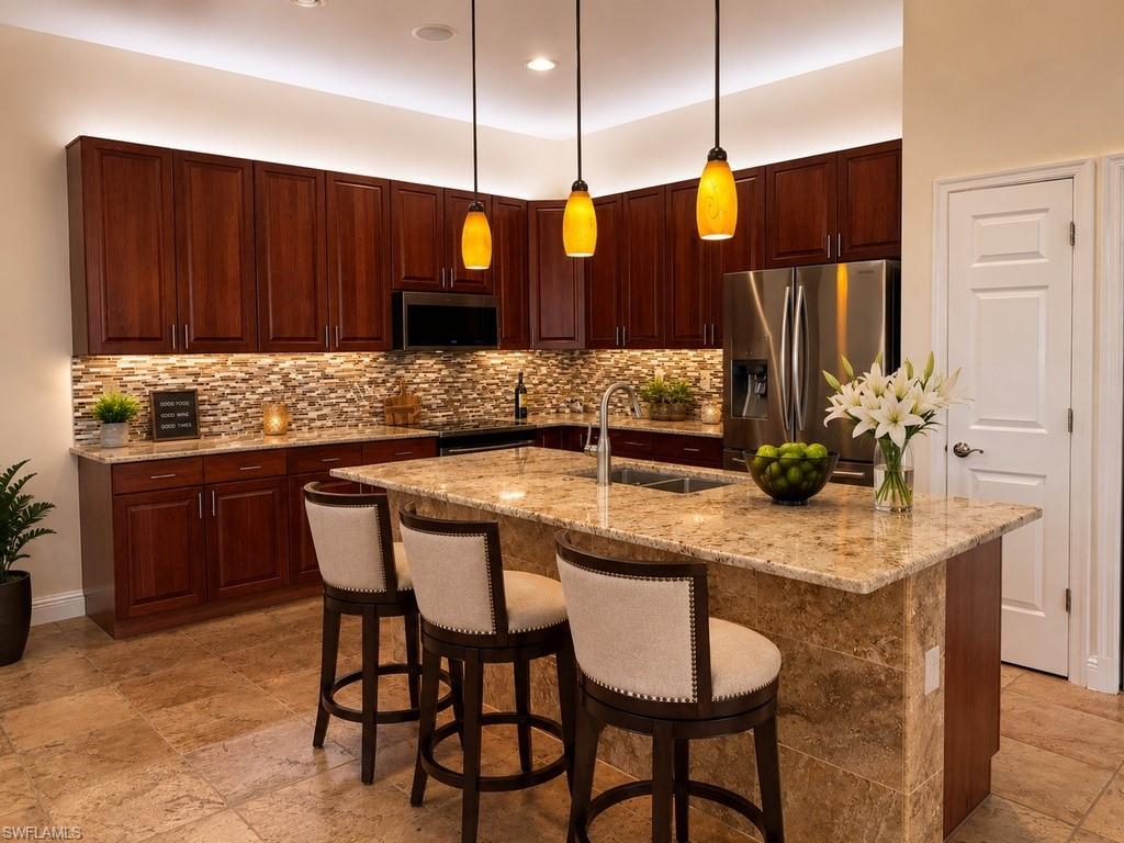 Expansive Gourmet kitchen featuring a large island with a stone countertop, dark wood cabinetry, a mosaic tile backsplash, stainless steel appliances, and tile flooring