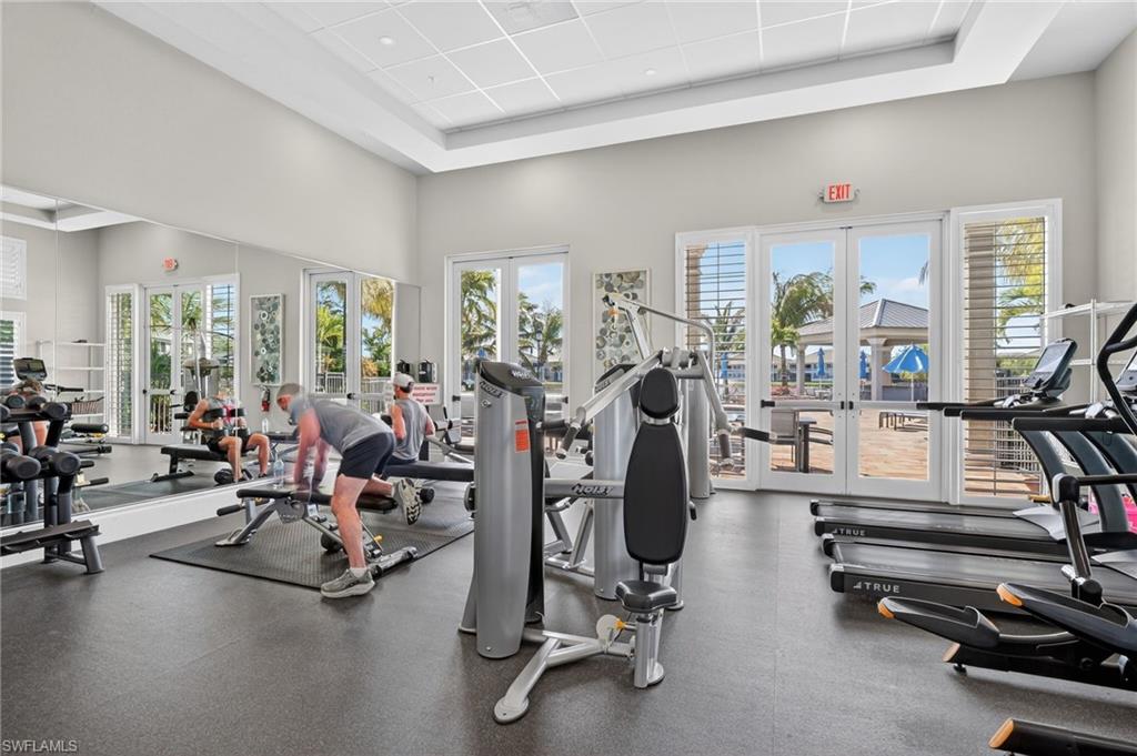 Fitness center featuring multiple treadmills, weight machines, and a large mirrored wall
