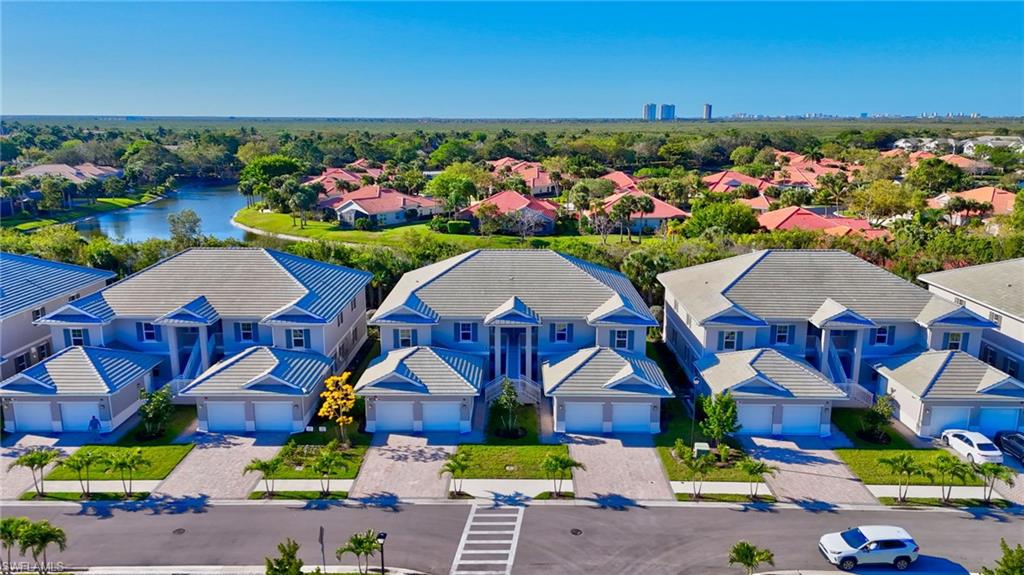 Contemporary residential exteriors featuring light blue siding with white trim, gray tile roofs, and attached two-car garages