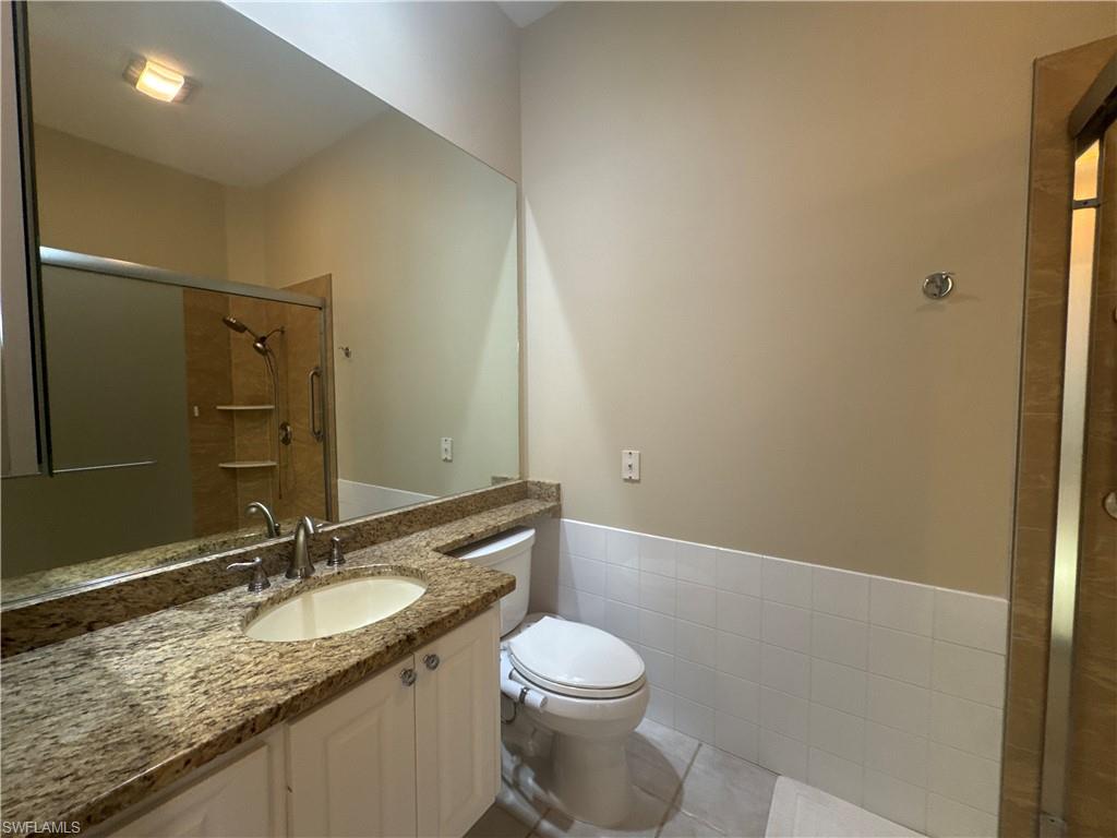 Spacious en-suite primary bath featuring dual vanities, a soaking tub, a unique walk-through shower with dual entrances, and two private water closets for added comfort and convenience