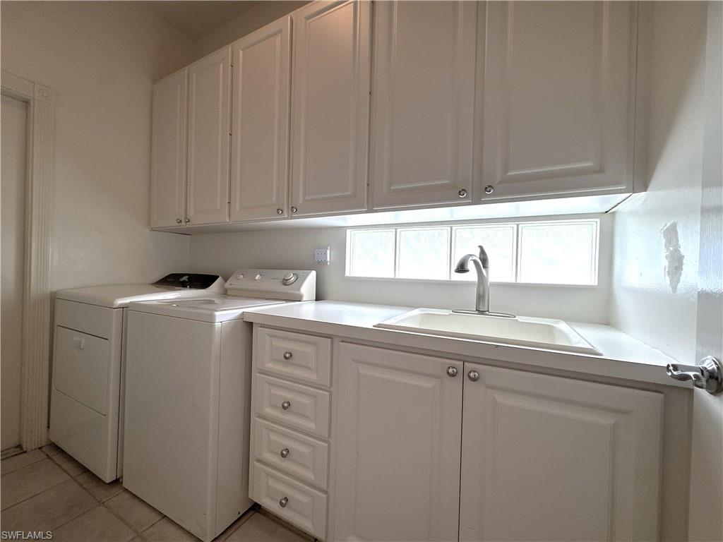 Laundry Room with utility tub, cabinets and hanging wrack.