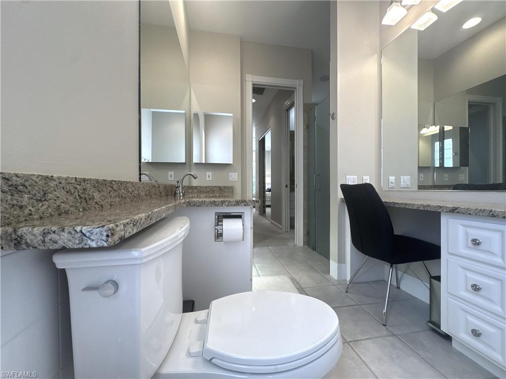 Spacious en-suite primary bath featuring dual vanities, a soaking tub, a unique walk-through shower with dual entrances, and two private water closets for added comfort and convenience