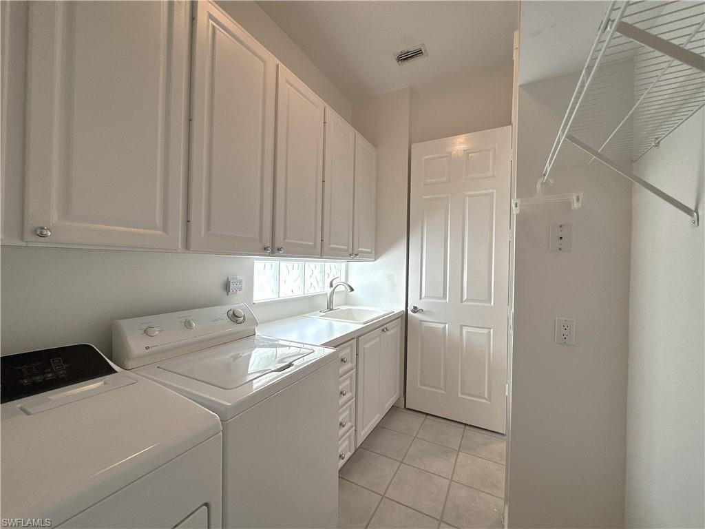 Laundry Room with utility tub, cabinets and hanging wrack.