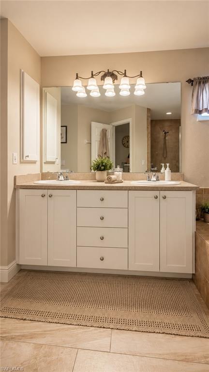 Bathroom featuring a double vanity with white cabinetry, a light-toned countertop, and two undermount sinks