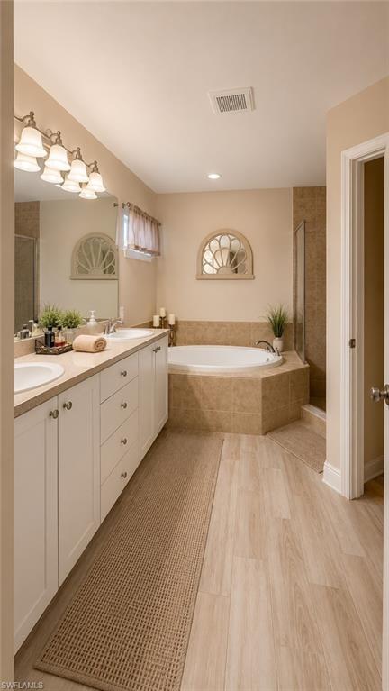 Bathroom featuring a dual vanity with white cabinetry, light countertops, and undermount sinks