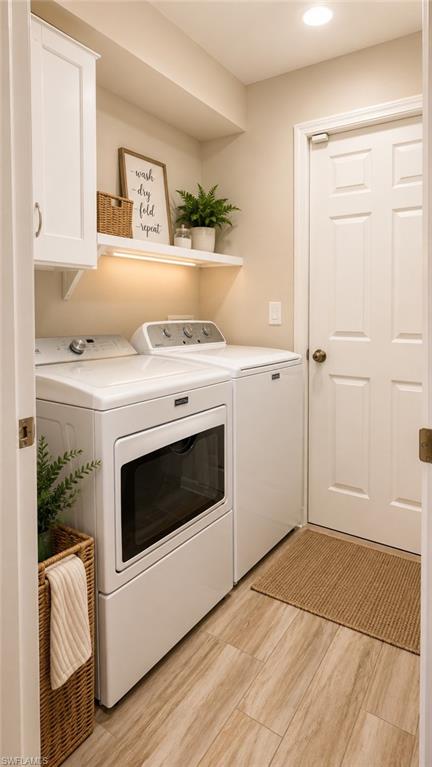 Dedicated laundry area featuring wood-finish flooring, white paneled cabinetry, and an illuminated floating shelf