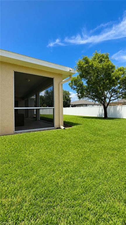 Expansive green lawn with a privacy fence