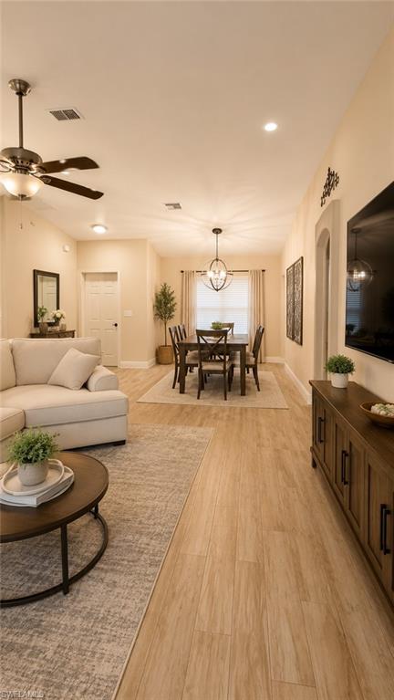 Open-concept living and dining areas featuring wood-finish flooring, recessed lighting, and a modern ceiling fan