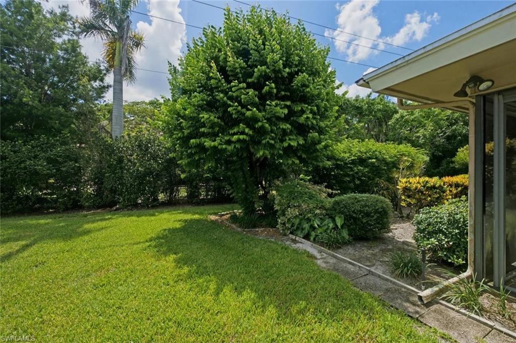 Expansive green lawn with mature trees and established shrubbery