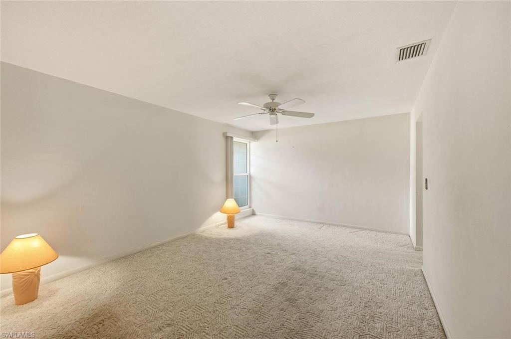 Carpeted room with white walls, a ceiling fan, and a single window