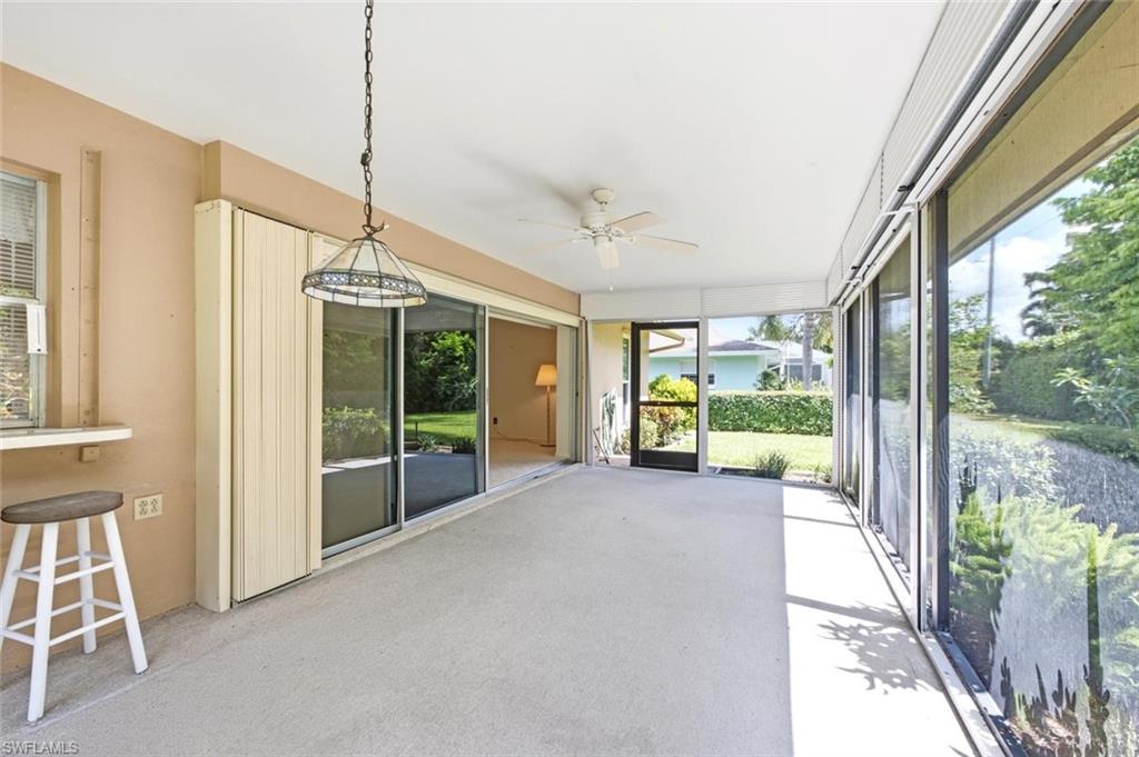Screened lanai featuring concrete flooring and a ceiling fan