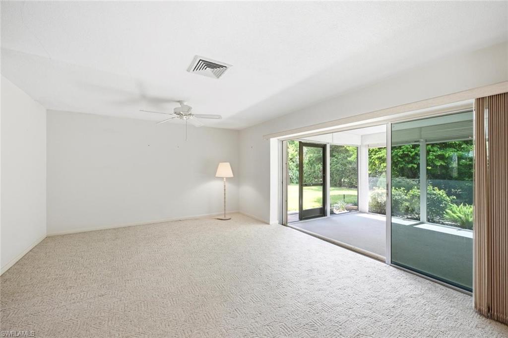 Carpeted interior space featuring white walls and a ceiling fan