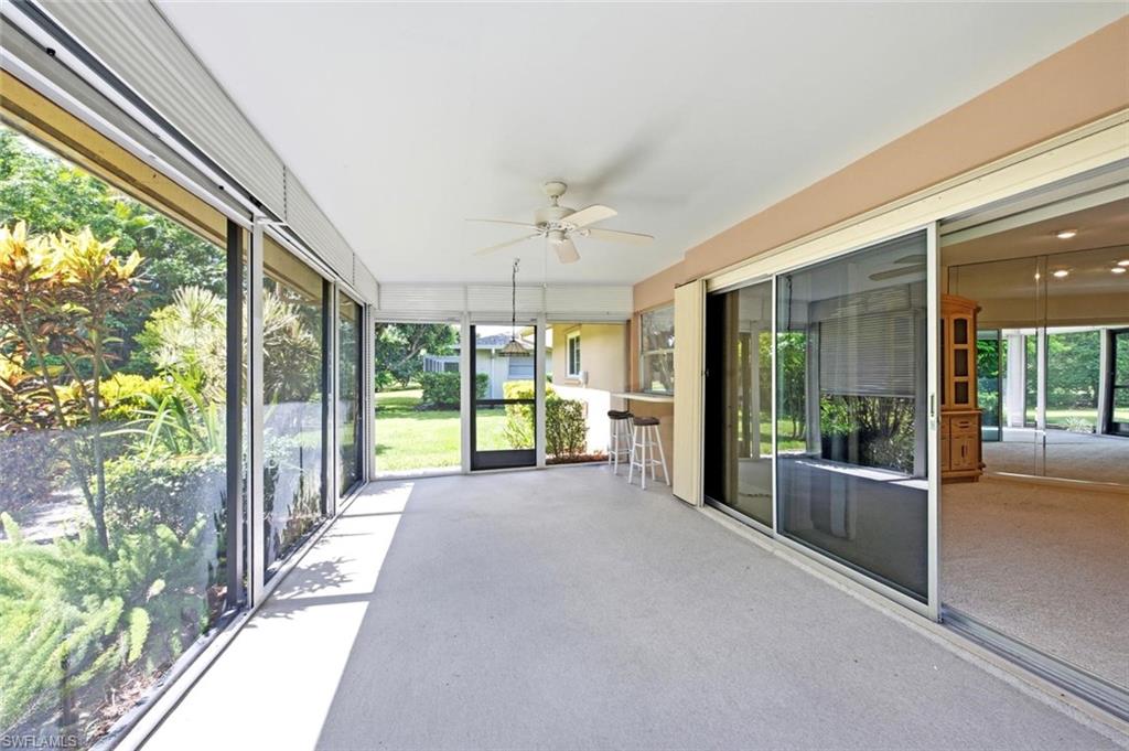 Screened patio area featuring a ceiling fan, light-colored flooring, and full-height screens