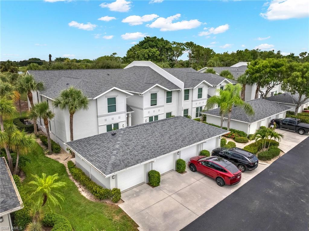 stucco townhomes featuring dark gray shingle roofing