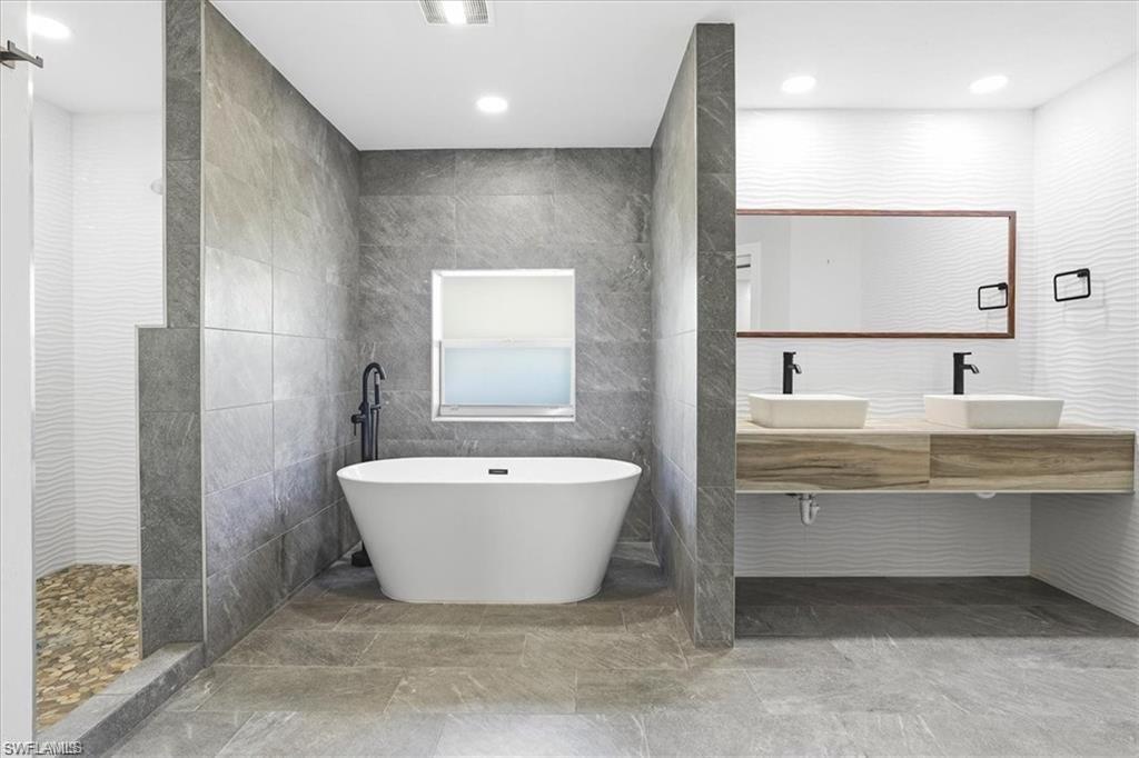 MASTER BATHROOM (1 OF 3) WITH SOAKING TUB, DUAL VANITIES, SEPARATE SHOWER, AND TOILET ROOM.