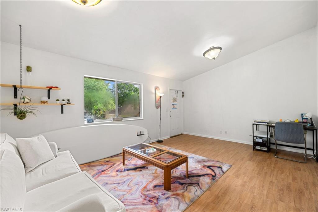 Recessed window offering natural light, wood-finish flooring, and built-in wall shelving