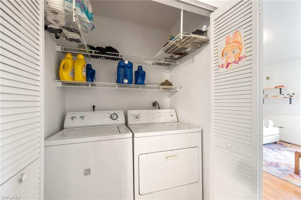 White louvered bi-fold doors open to a dedicated laundry area with a white washing machine and dryer, complemented by wire shelving