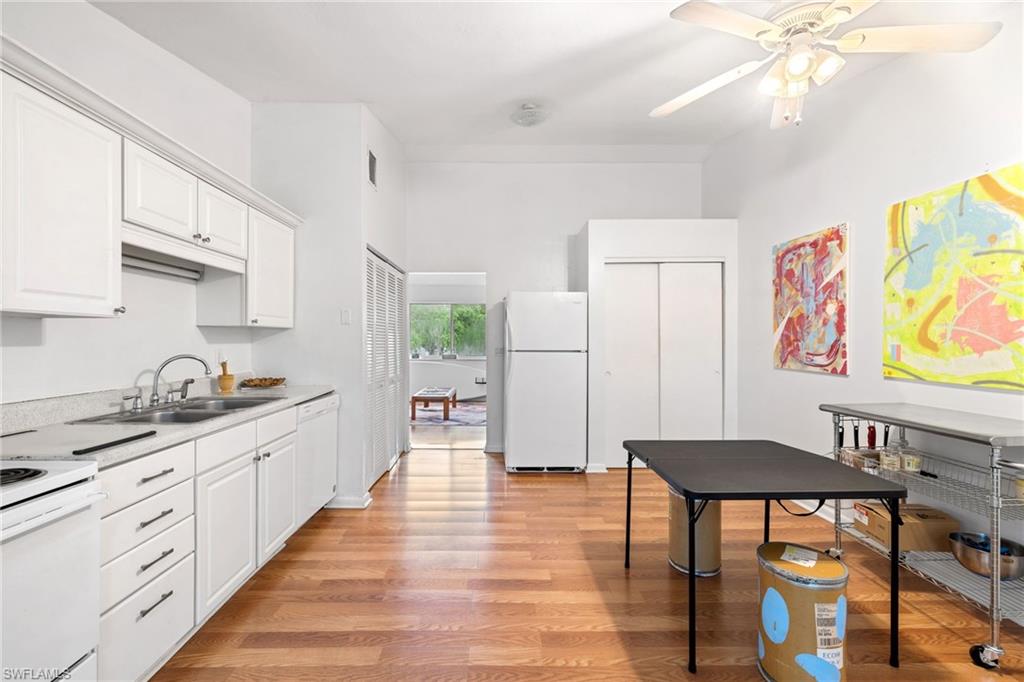 Kitchen featuring white cabinetry, light-toned countertops, wood-finish flooring, and a ceiling fan