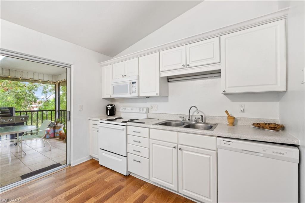 Kitchen featuring white cabinetry, wood-finish flooring, and light-toned countertops