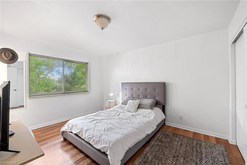 Wood-finish flooring with a large window and a ceiling-mounted light fixture