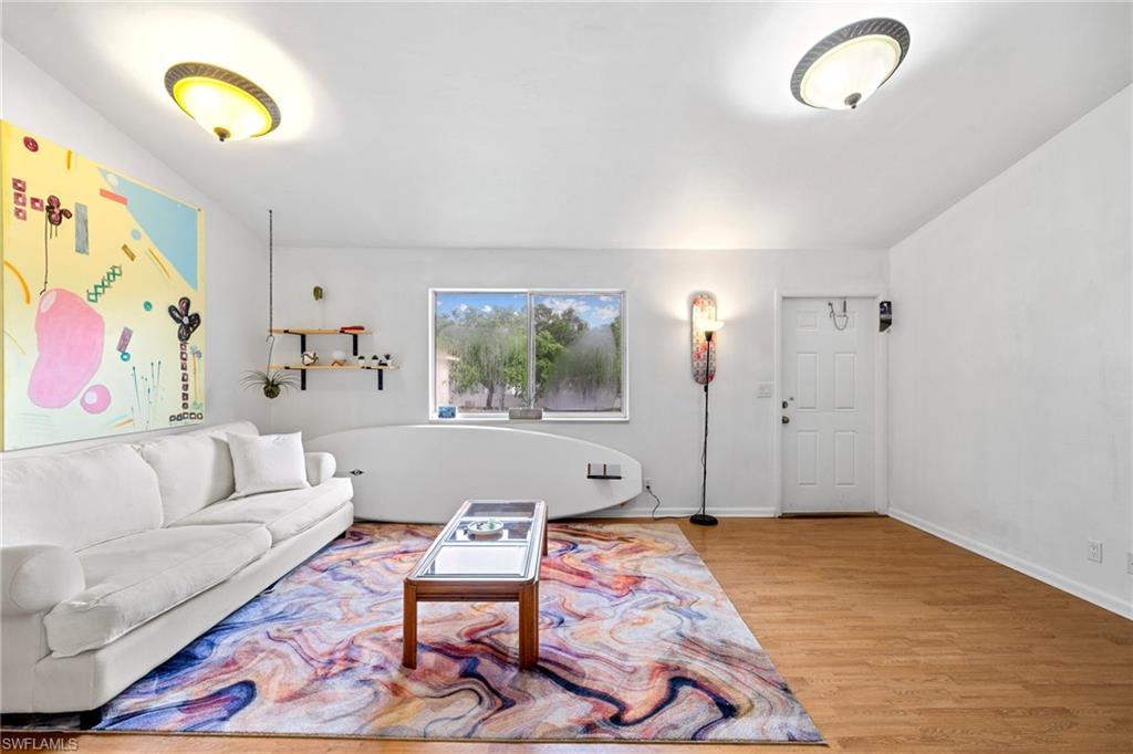 Hardwood-style flooring throughout, white walls, and a window with exterior views