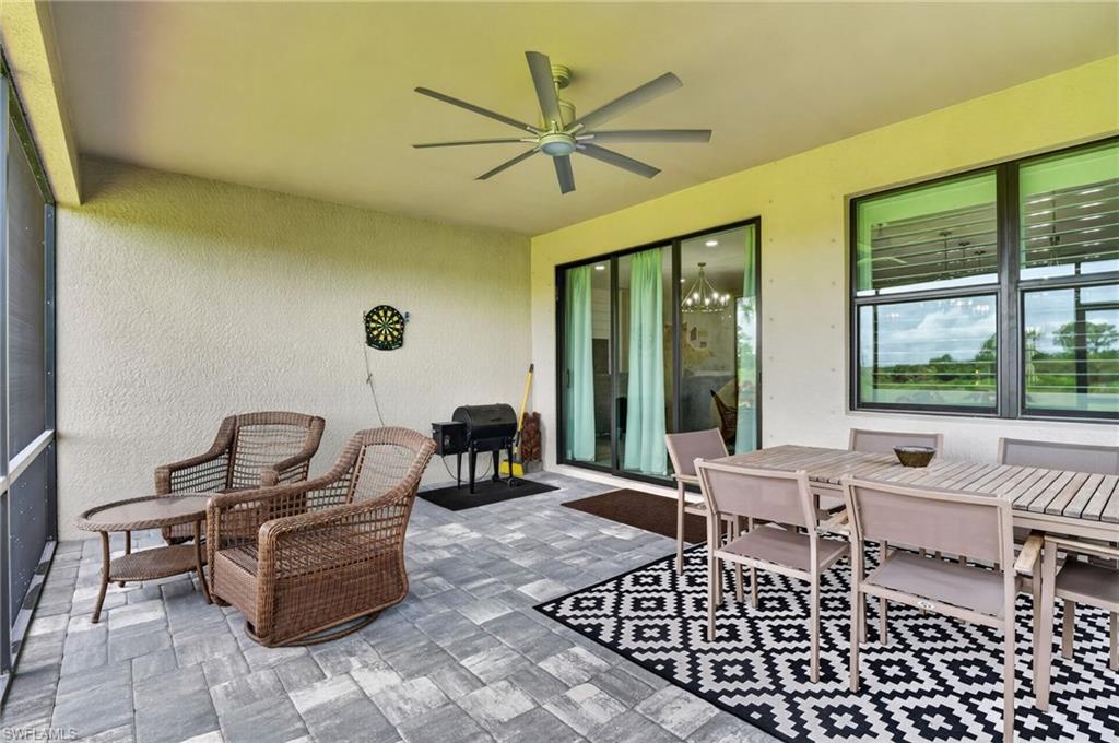 Screened patio featuring paver flooring, a ceiling fan, and sliding glass doors