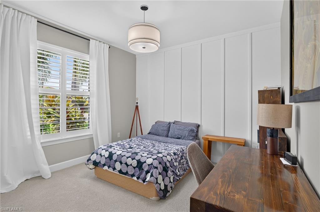 Interior room featuring a large window with plantation shutters and white drapery
