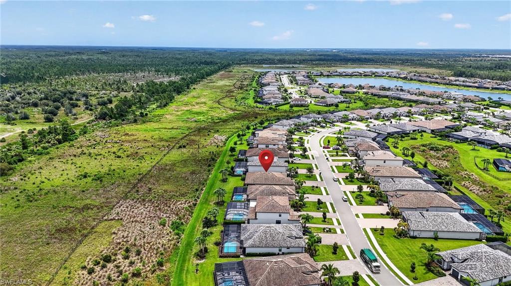 Aerial perspective highlighting a residential development bordered by natural green space and distant lakes
