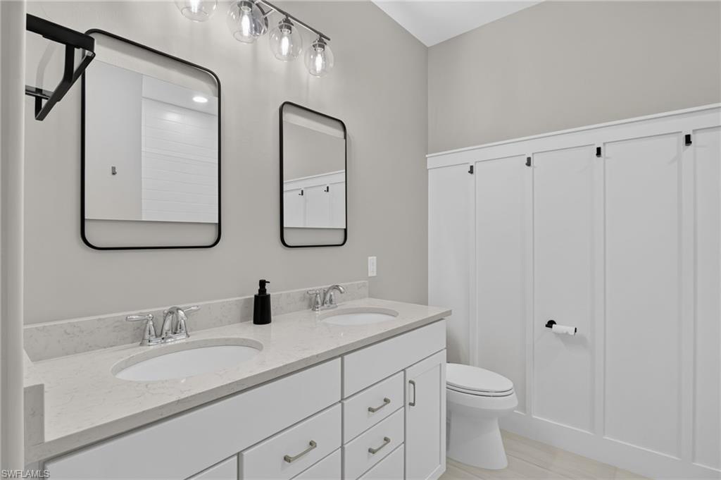 Dual vanity with white cabinetry and integrated sinks set in a light-toned countertop