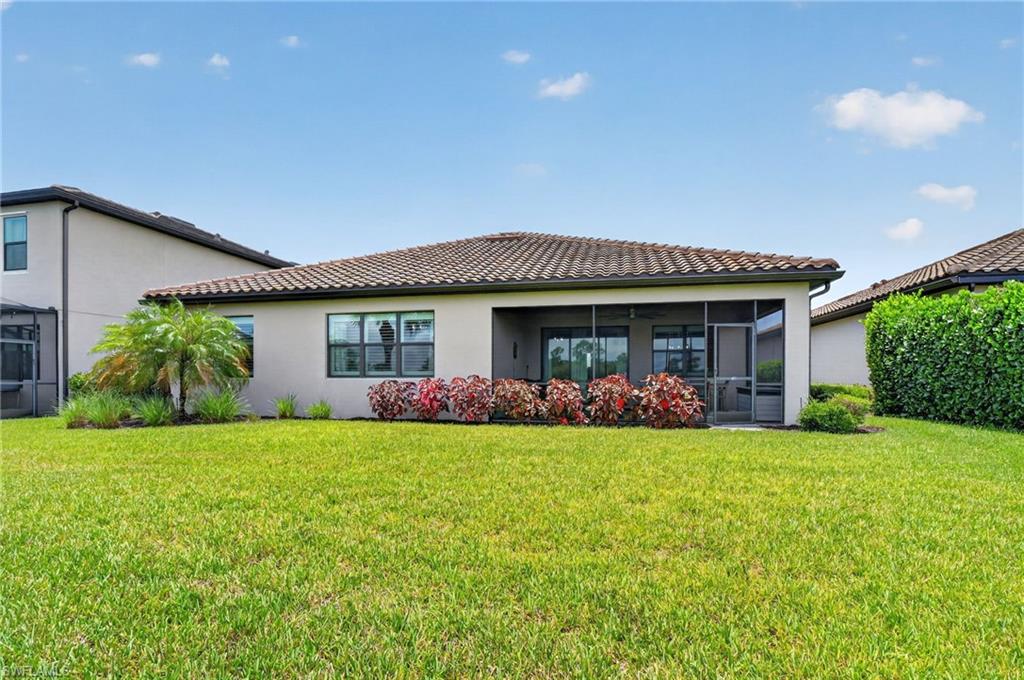 Expansive green lawn surrounds a rear elevation featuring a screened patio
