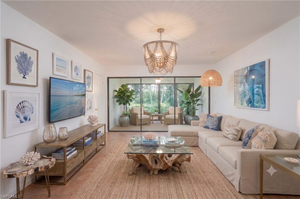 Living room with view into all season room virtually staged to provide design inspiration and ideas for furniture placement.