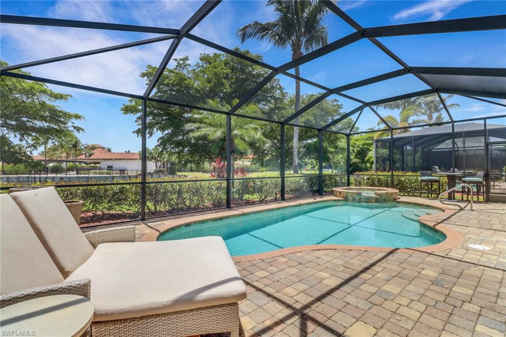 View of pool featuring a patio, a pool with connected hot tub, and a lanai