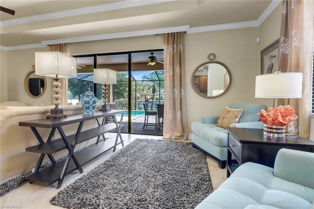 Living room featuring ceiling fan, ornamental molding, a sunroom, and light tile patterned flooring
