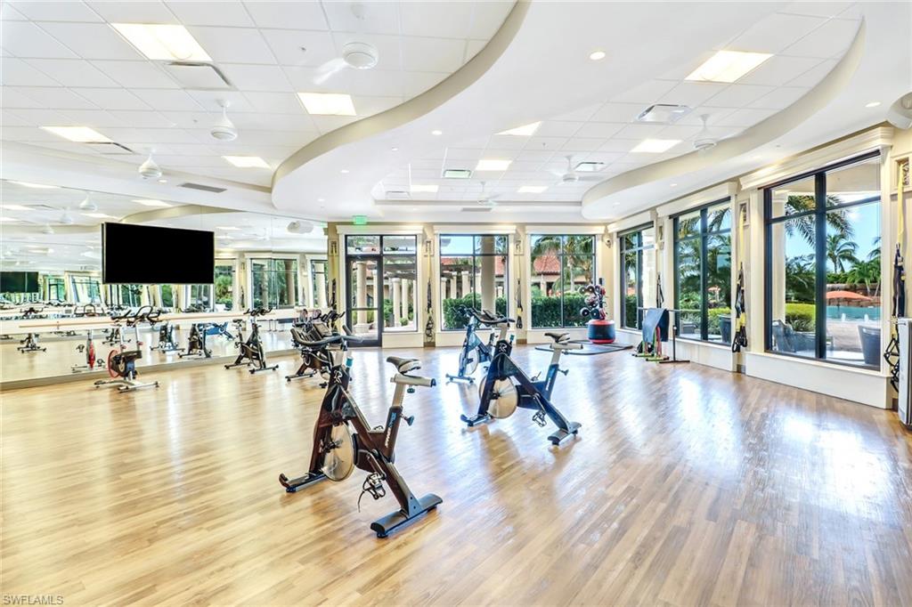 Exercise room featuring a paneled ceiling, plenty of natural light, and wood finished floors