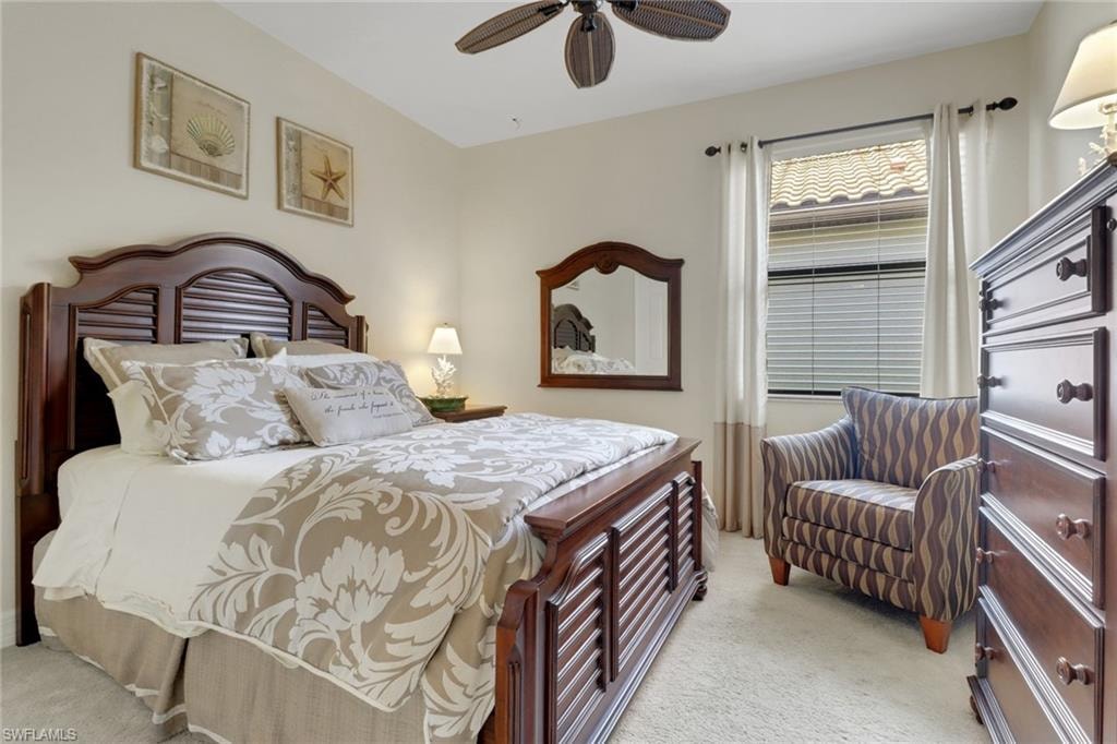 Bedroom with light colored carpet and a ceiling fan