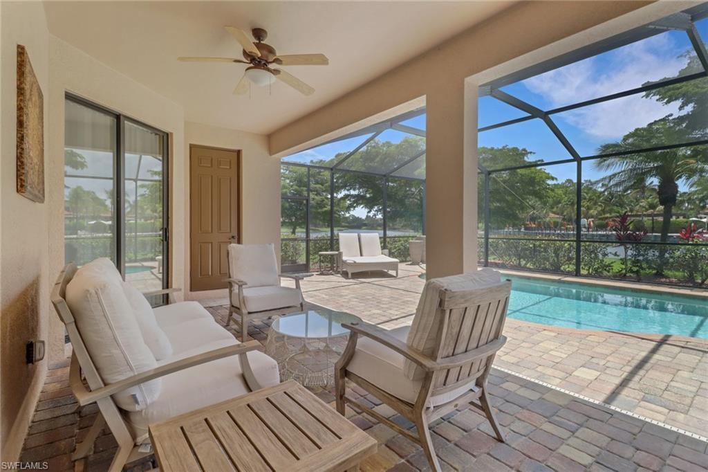 View of patio featuring an outdoor pool, outdoor lounge area, glass enclosure, and ceiling fan