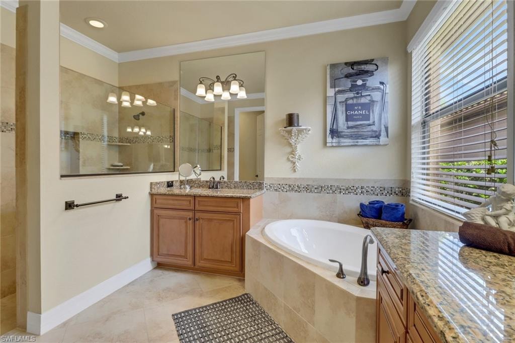 Full bath featuring vanity, ornamental molding, walk in shower, a garden tub, and tile patterned floors