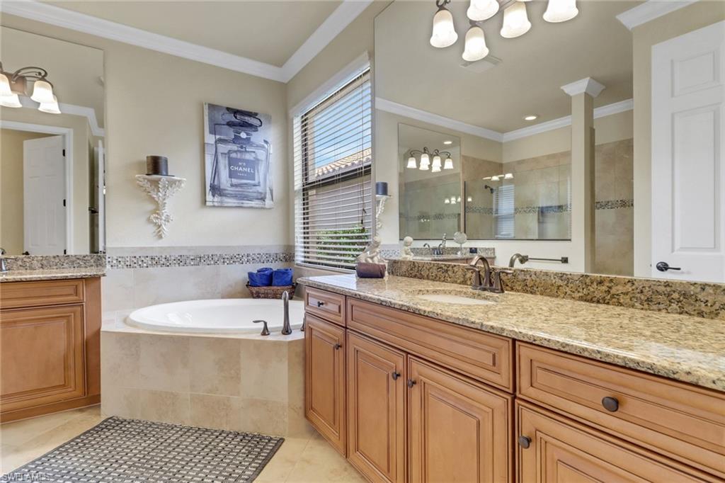 Full bath with a chandelier, vanity, tile patterned floors, tiled shower, and a bath