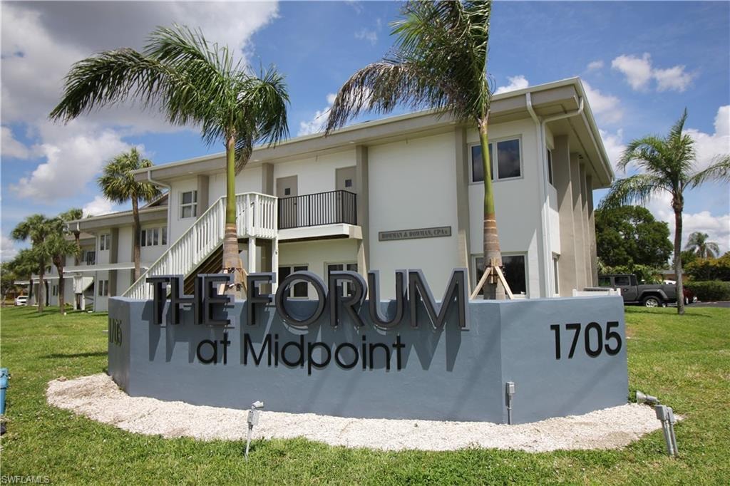 Contemporary two-story building featuring clean lines, multiple windows, and a prominent entrance sign