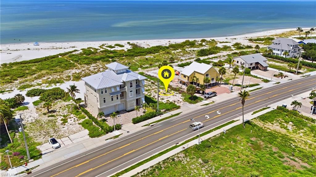 Coastal property featuring a light-colored exterior with a multi-level design and a metal roof - Virtually Edited Image