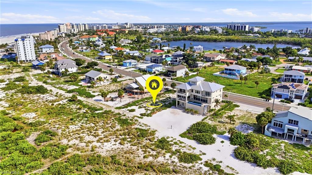 Aerial perspective showcasing a coastal community with prominent beach frontage - Virtually Edited Image