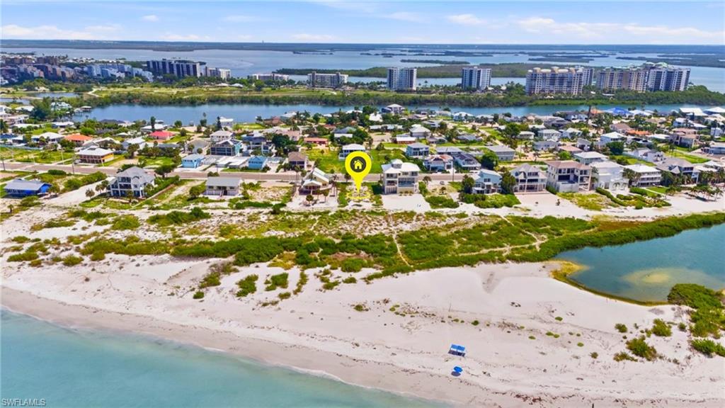 Aerial perspective showcasing a coastal property with direct beach frontage - Virtually Edited Image